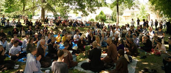 Pratiquants assis pour pique-niquer ensemble sous le grand chêne du hameau du bas