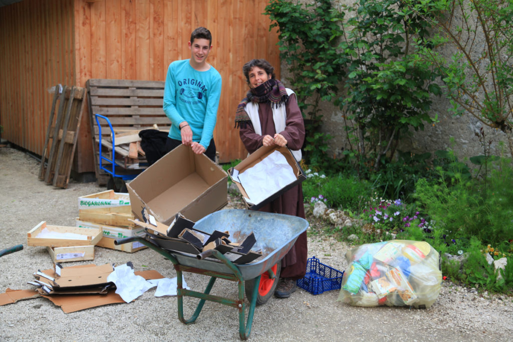 Une amie et son fils sont debout devant une brouette et ils déplient des cartons pour les recycler